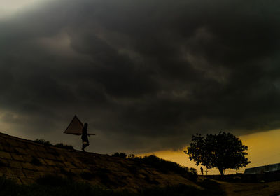 Silhouette of road sign against sky during sunset