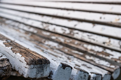 Side perspective view of an old weathered wooden bench.