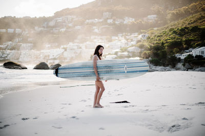 Woman with arms raised on beach