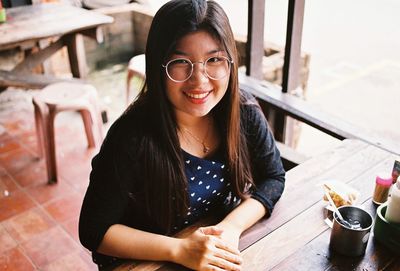 Portrait of smiling young woman sitting at cafe