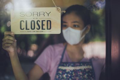 Portrait of woman holding glass sign