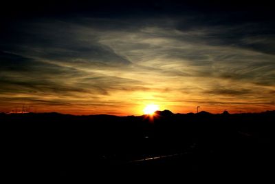 Silhouette landscape against sky at sunset