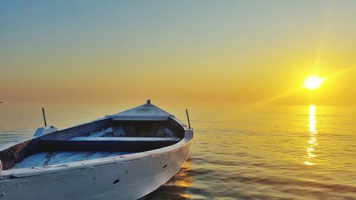 Boat in sea at sunset