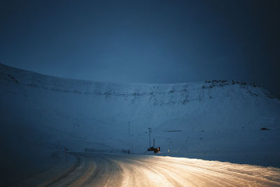 Low section of man walking on snow covered landscape