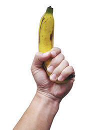 Close-up of hand holding fruit against white background