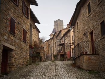 Narrow street amidst medieval buildings against sky