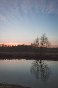 Scenic view of lake against sky at sunset