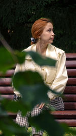 Woman looking away while sitting outdoors