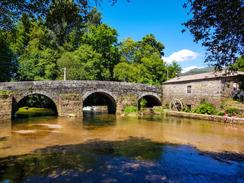 Arch bridge over river against sky