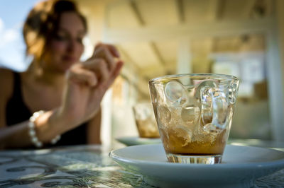 Midsection of woman drinking glass on table