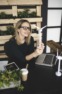 Young woman using phone on table