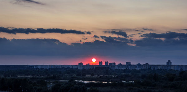 View of cityscape against cloudy sky