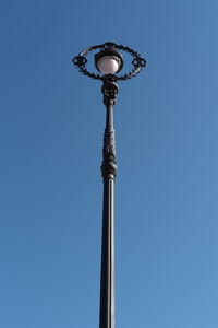 Low angle view of street light against blue sky