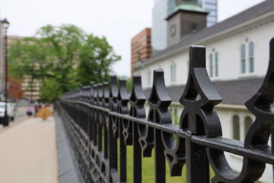 Metal fence by buildings in city