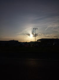 Silhouette street against sky during sunset