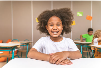 Portrait of smiling girl sitting on table