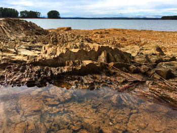 Scenic view of rocks on beach against sky