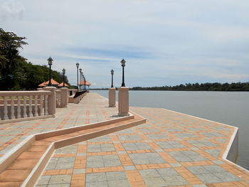 Footpath by swimming pool against sky