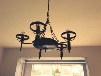 Low angle view of illuminated chandelier hanging on ceiling