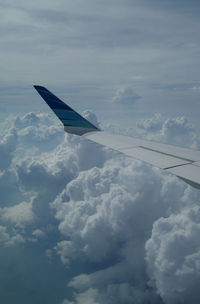 Cropped image of airplane flying over clouds