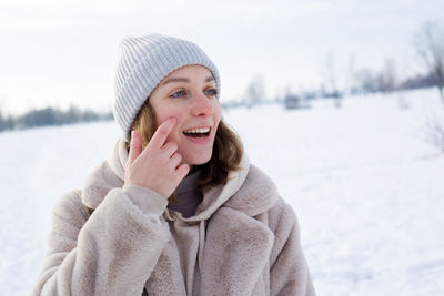 Portrait of smiling young woman in snow