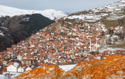 Aerial view of townscape by snow covered mountain
