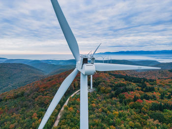 Close-up on the propellers of a wind turbine during a misty morning and sunrise. green energy. 