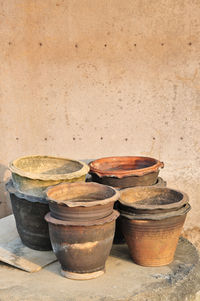 High angle view of clay pots on table by wall