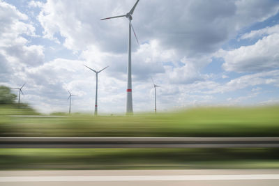 Blurred motion of plants against windmills