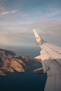 Airplane flying over sea against sky