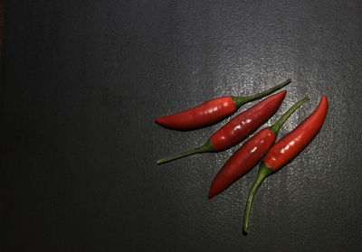 Directly above shot of red chili peppers on black background