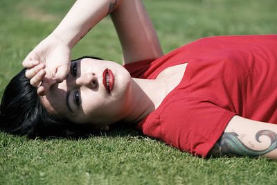 Portrait of young woman lying on grass