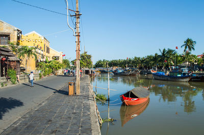 Boats moored on shore against clear sky