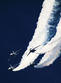 Low angle view of airshow against sky