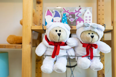 Close-up of stuffed toy hanging on wood at home