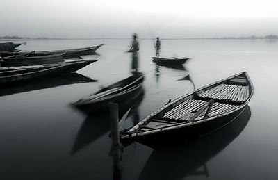 Fishing boat moored in sea against sky