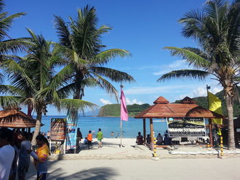 People at beach against blue sky