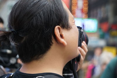 Rear view of man using mobile phone outdoors