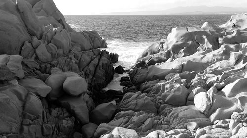 Panoramic view of rocks on beach against sky