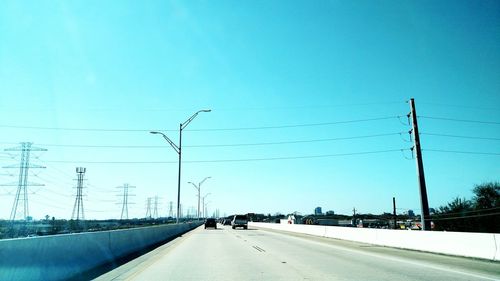 Cars on road against cloudy sky