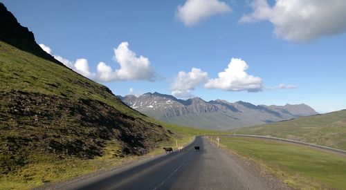 Country road against cloudy sky