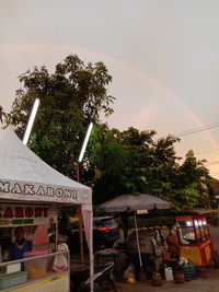 Group of people against rainbow in city