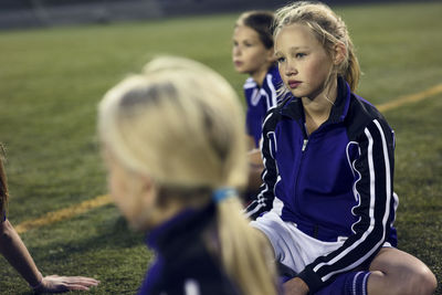 High angle view of girls relaxing on soccer field