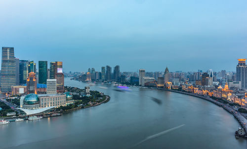 Illuminated buildings in city against sky