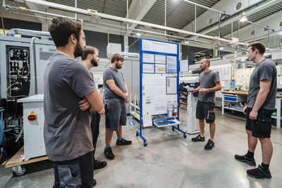 Maintenance worker having discussion while standing at industry