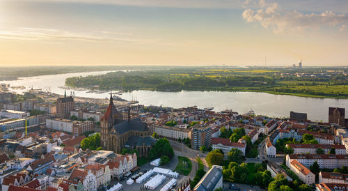 High angle view of townscape by river against sky