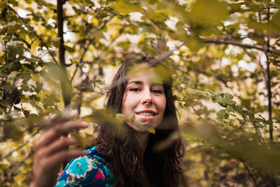 Portrait of smiling woman amidst trees