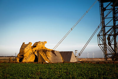 Traditional windmill on field against clear blue sky