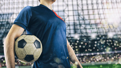 Rear view of man standing on soccer field