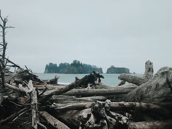 Stack of rocks by sea against clear sky